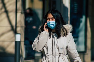 Paris Fransa 20 Mart 2021 'de Paris sokaklarında yürüyen ve nüfusu zapt etmek için koronavirüsten kendini korumak için maske takan bir yayaydı.