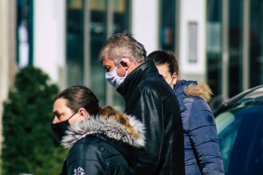 Paris Fransa 20 Mart 2021 'de Paris sokaklarında yürüyen ve nüfusu zapt etmek için koronavirüsten kendini korumak için maske takan bir yayaydı.