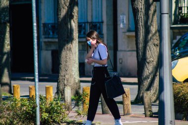 Coronavirus salgını sırasında Reims sokaklarında yürüyen ve Fransa 'yı etkileyen koronavirüsten kendilerini korumak için maske takan 29 Mart 2021' de Fransa 'yı ele geçirdi.