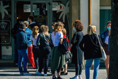 Fransa 'yı 1 Nisan 2021' de Coronavirus salgını sırasında Reims sokaklarında yürüyen ve Fransa 'yı etkileyen koronavirüsten kendilerini korumak için maske takmış yayalar.