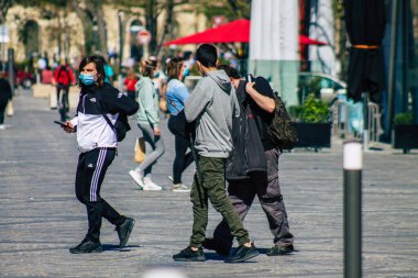 Fransa 'yı 1 Nisan 2021' de Coronavirus salgını sırasında Reims sokaklarında yürüyen ve Fransa 'yı etkileyen koronavirüsten kendilerini korumak için maske takmış yayalar.