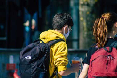 Fransa 'yı 1 Nisan 2021' de Coronavirus salgını sırasında Reims sokaklarında yürüyen ve Fransa 'yı etkileyen koronavirüsten kendilerini korumak için maske takmış yayalar.