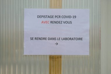 Reims hastanesinin ana girişinin karşısındaki Coronavirus tarama merkezinin 28 Nisan 2021 'de Fransa' da olduğunu söylüyor.
