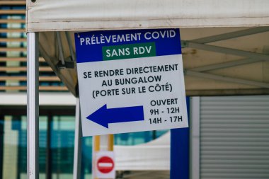 Reims hastanesinin ana girişinin karşısındaki Coronavirus tarama merkezinin 28 Nisan 2021 'de Fransa' da olduğunu söylüyor.