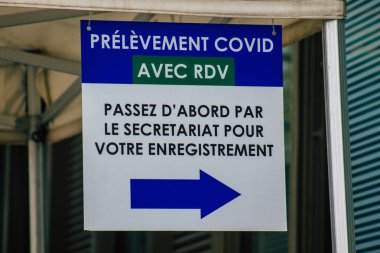Reims hastanesinin ana girişinin karşısındaki Coronavirus tarama merkezinin 28 Nisan 2021 'de Fransa' da olduğunu söylüyor.
