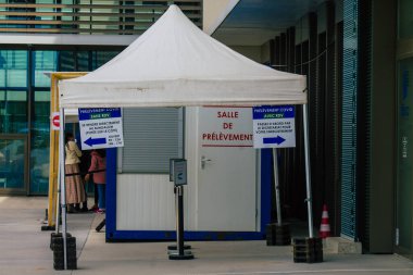 Reims hastanesinin ana girişinin karşısındaki Coronavirus tarama merkezinin 28 Nisan 2021 'de Fransa' da olduğunu söylüyor.