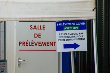 Reims hastanesinin ana girişinin karşısındaki Coronavirus tarama merkezinin 28 Nisan 2021 'de Fransa' da olduğunu söylüyor.