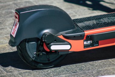 Seville İspanya 01 Temmuz 2021 Seville sokaklarında park edilmiş küçük bir iç yanmalı motorlar ve merkezde bir güverte ile çalışan elektrikli scooter.