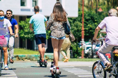 Sevilla İspanya 2 Temmuz 2021 Seville sokaklarında elektrikli scooterla dolaşan insanlar, küçük bir iç yanmalı motorlar ve merkezde bir güverte ile çalışıyorlar.