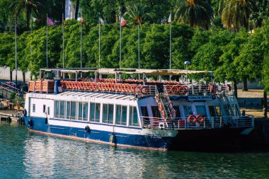 Seville İspanya 7 Temmuz 2021 Guadalquivir Nehri 'ne demirlemiş turist tekneleri, İspanya' nın güneyinde, sembolik bir şehir ve Endülüs bölgesinin başkenti olan Sevilla 'yı geçmektedir.