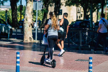 Seville Spain July 09, 2021 People rolling with an electric scooter in the streets of Seville, operating with a small utility internal combustion engines and a deck in the center