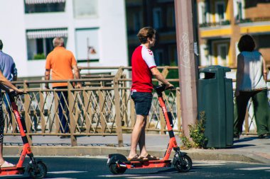 Seville Spain July 09, 2021 People rolling with an electric scooter in the streets of Seville, operating with a small utility internal combustion engines and a deck in the center