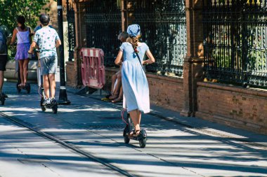Seville İspanya 11 Ağustos 2021 Seville sokaklarında elektrikli scooterla dolaşan insanlar, küçük bir iç yanmalı motorlar ve merkezde bir güverte ile çalışıyorlar.
