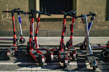 Seville İspanya 11 Ağustos 2021 Sevilla caddelerinde park edilmiş küçük bir iç yanmalı motorlar ve merkezde bir güverte ile çalışan elektrikli scooter.