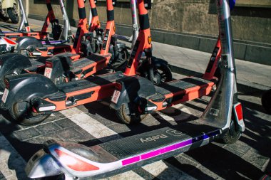 Seville İspanya 11 Ağustos 2021 Sevilla caddelerinde park edilmiş küçük bir iç yanmalı motorlar ve merkezde bir güverte ile çalışan elektrikli scooter.