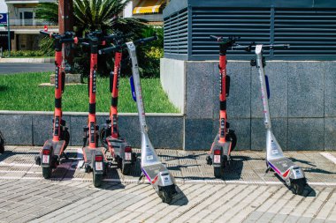 Seville İspanya 21 Ağustos 2021 Sevilla caddelerinde park etmiş küçük bir iç yanmalı motorlar ve merkezde bir güverte ile çalışan elektrikli scooter.