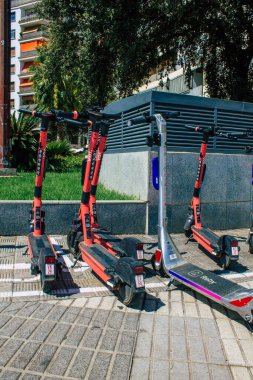 Seville İspanya 21 Ağustos 2021 Sevilla caddelerinde park etmiş küçük bir iç yanmalı motorlar ve merkezde bir güverte ile çalışan elektrikli scooter.