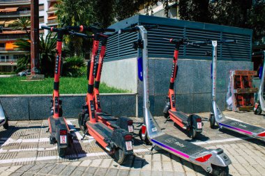 Seville İspanya 21 Ağustos 2021 Sevilla caddelerinde park etmiş küçük bir iç yanmalı motorlar ve merkezde bir güverte ile çalışan elektrikli scooter.