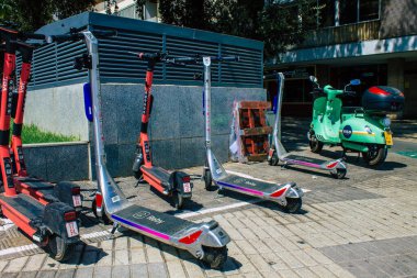 Seville İspanya 21 Ağustos 2021 Sevilla caddelerinde park etmiş küçük bir iç yanmalı motorlar ve merkezde bir güverte ile çalışan elektrikli scooter.