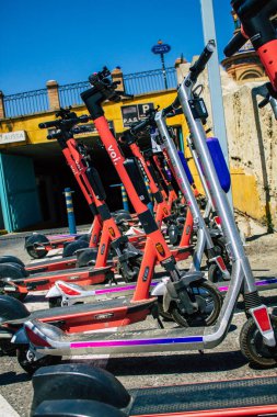 Seville İspanya 21 Ağustos 2021 Sevilla caddelerinde park etmiş küçük bir iç yanmalı motorlar ve merkezde bir güverte ile çalışan elektrikli scooter.