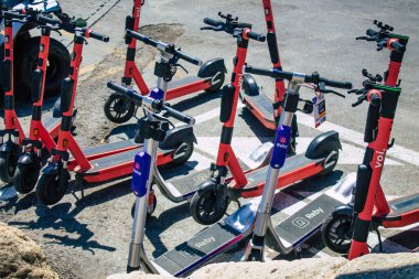 Seville İspanya 21 Ağustos 2021 Sevilla caddelerinde park etmiş küçük bir iç yanmalı motorlar ve merkezde bir güverte ile çalışan elektrikli scooter.