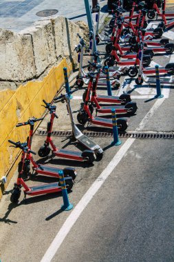 Seville İspanya 21 Ağustos 2021 Sevilla caddelerinde park etmiş küçük bir iç yanmalı motorlar ve merkezde bir güverte ile çalışan elektrikli scooter.