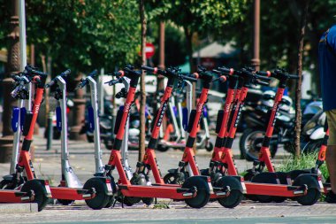Seville İspanya 21 Ağustos 2021 Sevilla caddelerinde park etmiş küçük bir iç yanmalı motorlar ve merkezde bir güverte ile çalışan elektrikli scooter.