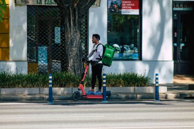 Sevilla İspanya 21 Ağustos 2021 Seville sokaklarında elektrikli scooterla dolaşan insanlar, küçük bir iç yanmalı motorlar ve merkezde bir güverte ile çalışıyorlar.