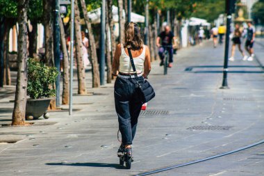 Sevilla İspanya 21 Ağustos 2021 Seville sokaklarında elektrikli scooterla dolaşan insanlar, küçük bir iç yanmalı motorlar ve merkezde bir güverte ile çalışıyorlar.
