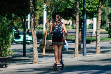 Sevilla İspanya 21 Ağustos 2021 Seville sokaklarında elektrikli scooterla dolaşan insanlar, küçük bir iç yanmalı motorlar ve merkezde bir güverte ile çalışıyorlar.