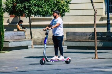 Sevilla İspanya 28 Ağustos 2021 Seville sokaklarında elektrikli scooterla dolaşan insanlar, küçük bir iç yanmalı motorlar ve merkezde bir güverte ile çalışıyorlar.