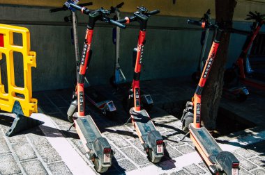 Seville İspanya Eylül 04, 2021 Seville sokaklarında park edilmiş küçük bir iç yanmalı motorlar ve merkezde bir güverte ile çalışan elektrikli scooter kiralamak için