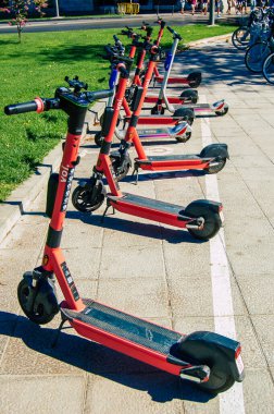 Seville İspanya Eylül 04, 2021 Seville sokaklarında park edilmiş küçük bir iç yanmalı motorlar ve merkezde bir güverte ile çalışan elektrikli scooter kiralamak için