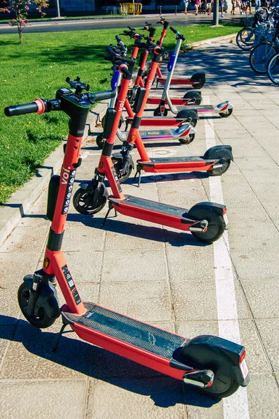 Seville İspanya Eylül 04, 2021 Seville sokaklarında park edilmiş küçük bir iç yanmalı motorlar ve merkezde bir güverte ile çalışan elektrikli scooter kiralamak için