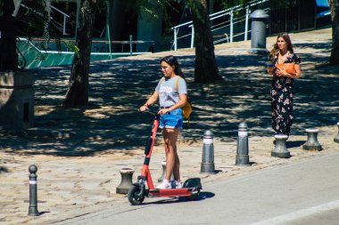 Seville İspanya 4 Eylül 2021 Seville sokaklarında elektrikli scooterla dolaşan insanlar, küçük bir iç yanmalı motorlar ve merkezde bir güverte ile çalışıyorlar.