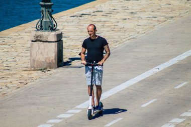 Seville İspanya 4 Eylül 2021 Seville sokaklarında elektrikli scooterla dolaşan insanlar, küçük bir iç yanmalı motorlar ve merkezde bir güverte ile çalışıyorlar.