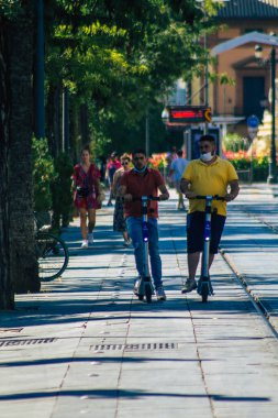 Seville İspanya 4 Eylül 2021 Seville sokaklarında elektrikli scooterla dolaşan insanlar, küçük bir iç yanmalı motorlar ve merkezde bir güverte ile çalışıyorlar.