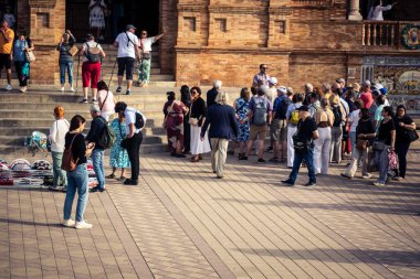 Seville, İspanya, 15 Ekim 2025 İspanya Plaza 'sını ziyaret eden turistler, Mara Luisa Parkında bir plaza. 1928 yılında 1929 'daki Ibero-Amerikan Sergisi için inşa edildi. Bölgesel Mimarlık.