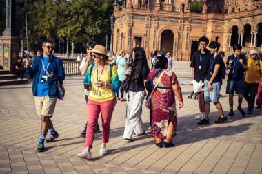 Seville, İspanya, 15 Ekim 2025 İspanya Plaza 'sını ziyaret eden turistler, Mara Luisa Parkında bir plaza. 1928 yılında 1929 'daki Ibero-Amerikan Sergisi için inşa edildi. Bölgesel Mimarlık.