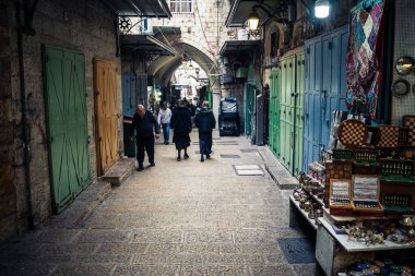 Kudüs, İsrail, 13 Aralık 2025 Kudüs 'ün Hristiyan Mahallesi' ndeki dar sokaklar ve atmosferik ışık oyunları yerel satıcılar tarafından sergilenen çeşitli ürünlere bir göz atma olanağı sağlıyor..