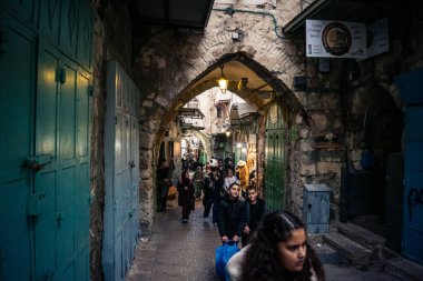 Kudüs, İsrail, 13 Aralık 2025 Kudüs 'ün Hristiyan Mahallesi' ndeki dar sokaklar ve atmosferik ışık oyunları yerel satıcılar tarafından sergilenen çeşitli ürünlere bir göz atma olanağı sağlıyor..