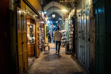 Kudüs, İsrail, 13 Aralık 2025 Kudüs 'ün Hristiyan Mahallesi' ndeki dar sokaklar ve atmosferik ışık oyunları yerel satıcılar tarafından sergilenen çeşitli ürünlere bir göz atma olanağı sağlıyor..