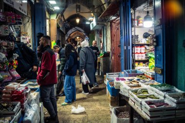 Kudüs, İsrail, 13 Aralık 2025 Kudüs 'ün Hristiyan Mahallesi' ndeki dar sokaklar ve atmosferik ışık oyunları yerel satıcılar tarafından sergilenen çeşitli ürünlere bir göz atma olanağı sağlıyor..