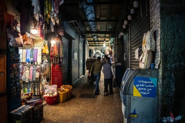 Kudüs, İsrail, 13 Aralık 2025 Kudüs 'ün Hristiyan Mahallesi' ndeki dar sokaklar ve atmosferik ışık oyunları yerel satıcılar tarafından sergilenen çeşitli ürünlere bir göz atma olanağı sağlıyor..