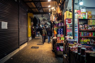 Kudüs, İsrail, 13 Aralık 2025 Kudüs 'ün Hristiyan Mahallesi' ndeki dar sokaklar ve atmosferik ışık oyunları yerel satıcılar tarafından sergilenen çeşitli ürünlere bir göz atma olanağı sağlıyor..