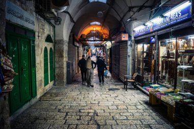 Kudüs, İsrail, 13 Aralık 2025 Kudüs 'ün Hristiyan Mahallesi' ndeki dar sokaklar ve atmosferik ışık oyunları yerel satıcılar tarafından sergilenen çeşitli ürünlere bir göz atma olanağı sağlıyor..