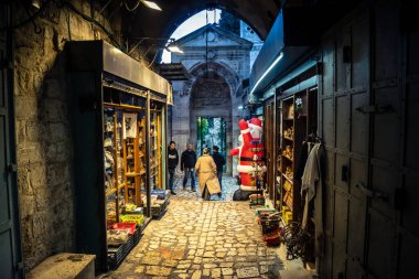 Kudüs, İsrail, 13 Aralık 2025 Kudüs 'ün Hristiyan Mahallesi' ndeki dar sokaklar ve atmosferik ışık oyunları yerel satıcılar tarafından sergilenen çeşitli ürünlere bir göz atma olanağı sağlıyor..