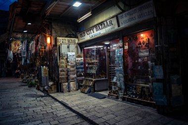 Kudüs, İsrail, 13 Aralık 2025 Kudüs 'ün Hristiyan Mahallesi' ndeki dar sokaklar ve atmosferik ışık oyunları yerel satıcılar tarafından sergilenen çeşitli ürünlere bir göz atma olanağı sağlıyor..