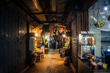 Kudüs, İsrail, 13 Aralık 2025 Kudüs 'ün Hristiyan Mahallesi' ndeki dar sokaklar ve atmosferik ışık oyunları yerel satıcılar tarafından sergilenen çeşitli ürünlere bir göz atma olanağı sağlıyor..