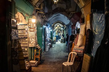 Kudüs, İsrail, 13 Aralık 2025 Kudüs 'ün Hristiyan Mahallesi' ndeki dar sokaklar ve atmosferik ışık oyunları yerel satıcılar tarafından sergilenen çeşitli ürünlere bir göz atma olanağı sağlıyor..